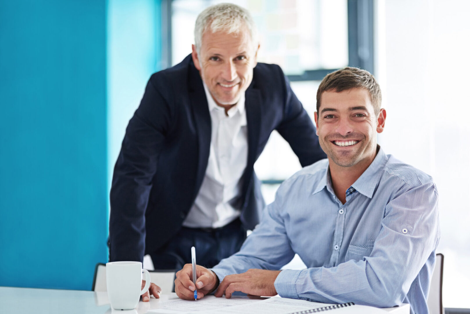 Two businessmen collaborating in a modern office setting.