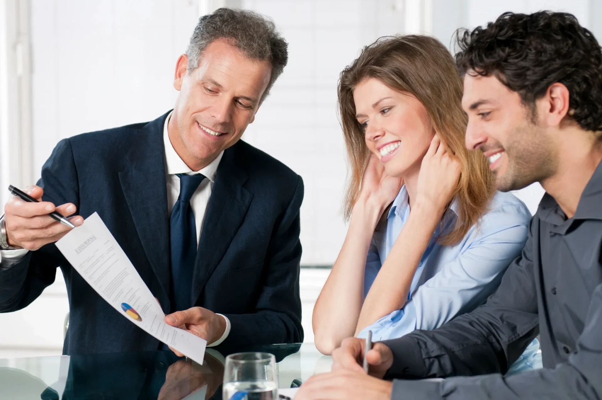 Businessman presenting a document to a couple in a meeting.
